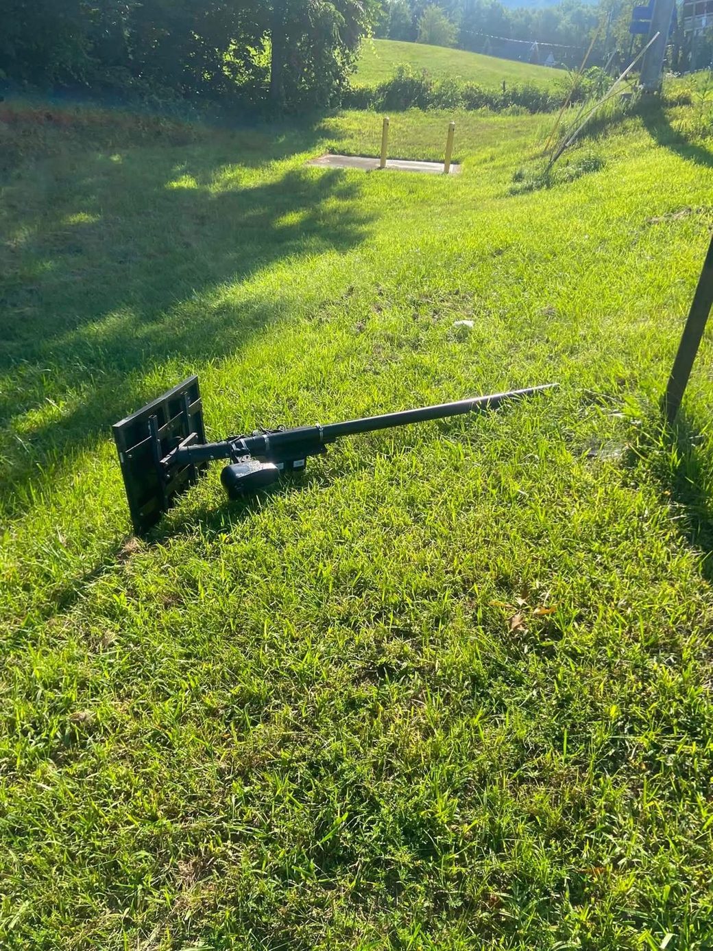 Close-up of the downed Flock camera unit and its solar panel lying in the grass.